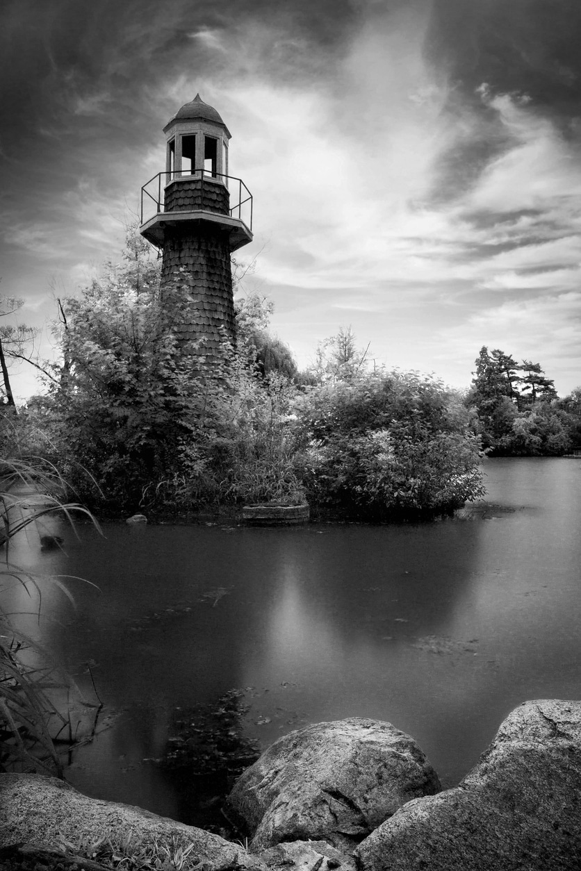 Black-and-white image of Palmer Park Lighthouse on Lake Frances in Detroit under a dramatic sky