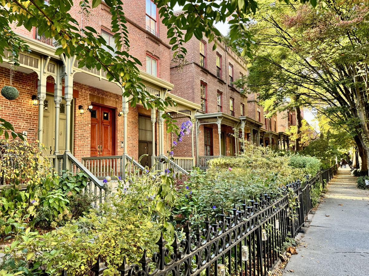 Astor Row, one of the best Harlem neighborhoods, with historic brick townhouses, porches, and garden