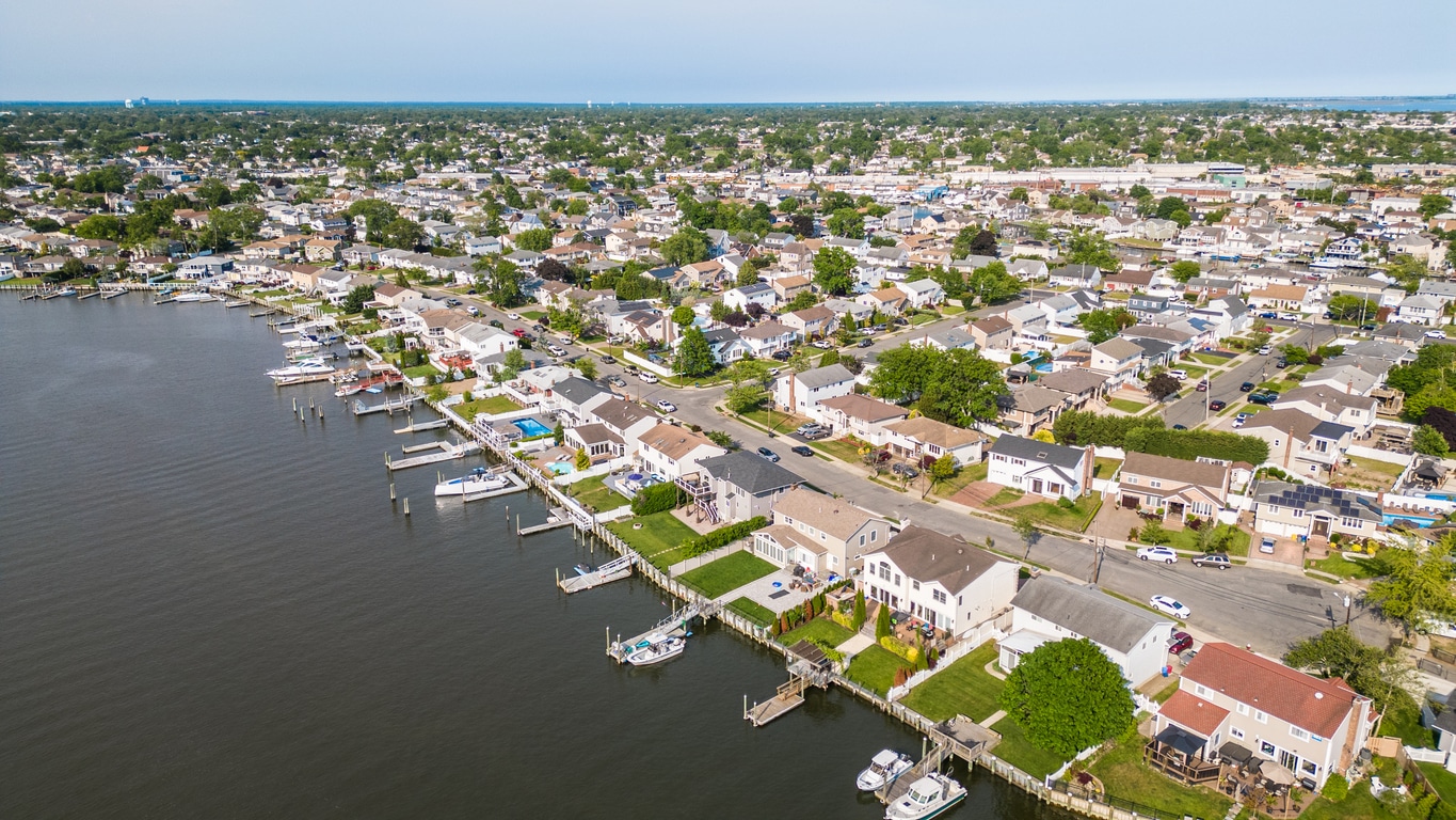 Aerial view of a Long Island bay with sailboats, marina, and nearby homes