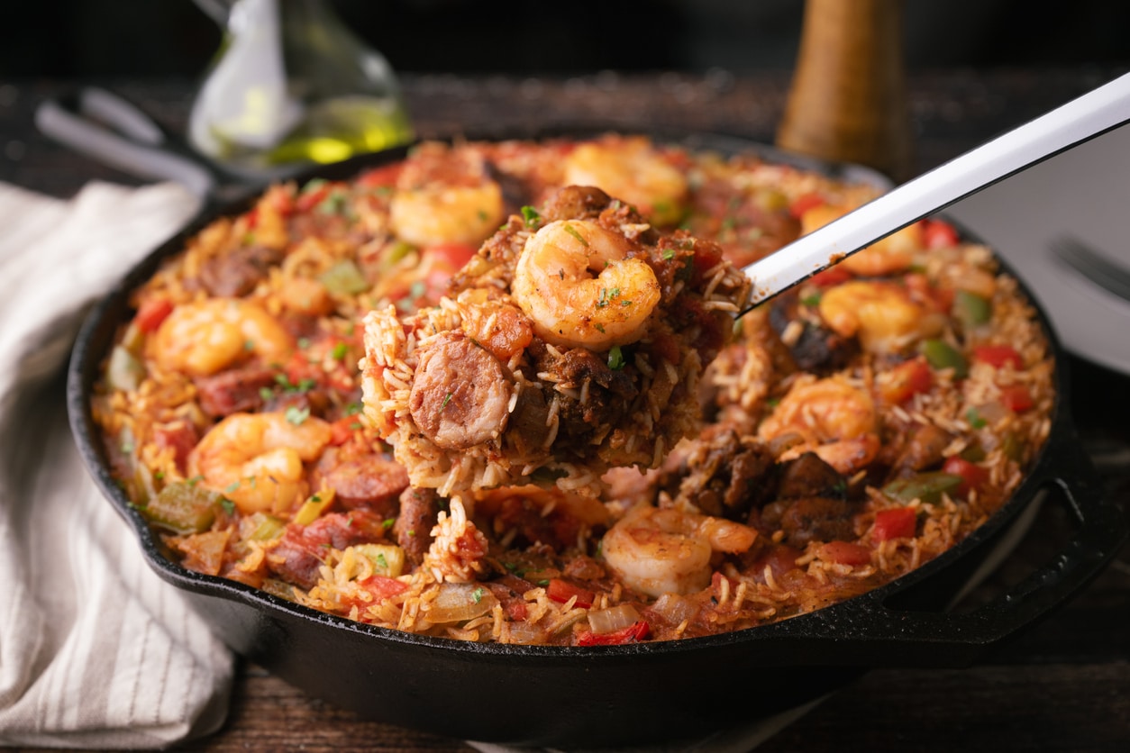 Person stirring a pot of jambalaya, a Louisiana Cajun-Creole staple for those living in Louisiana