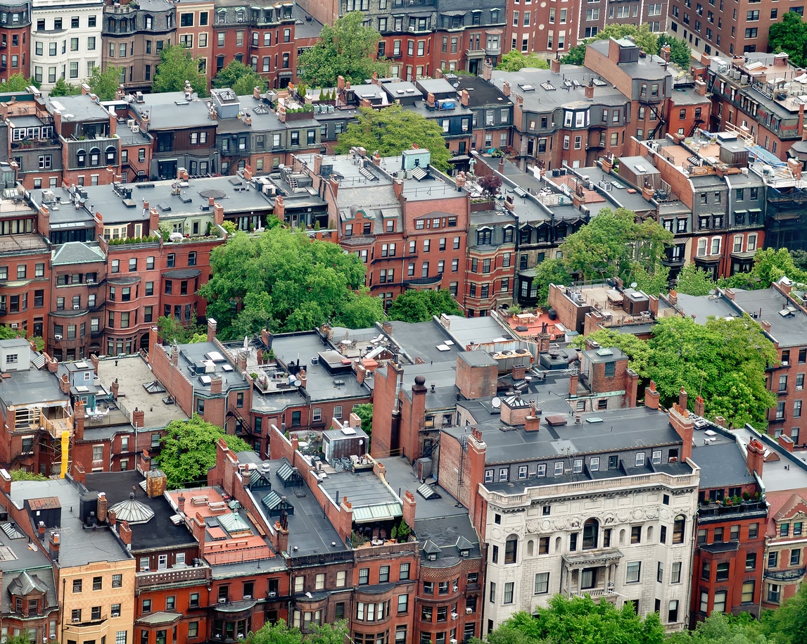 Aerial view of historic Boston brownstones with trees, highlighting Massachusetts’ classic architecture