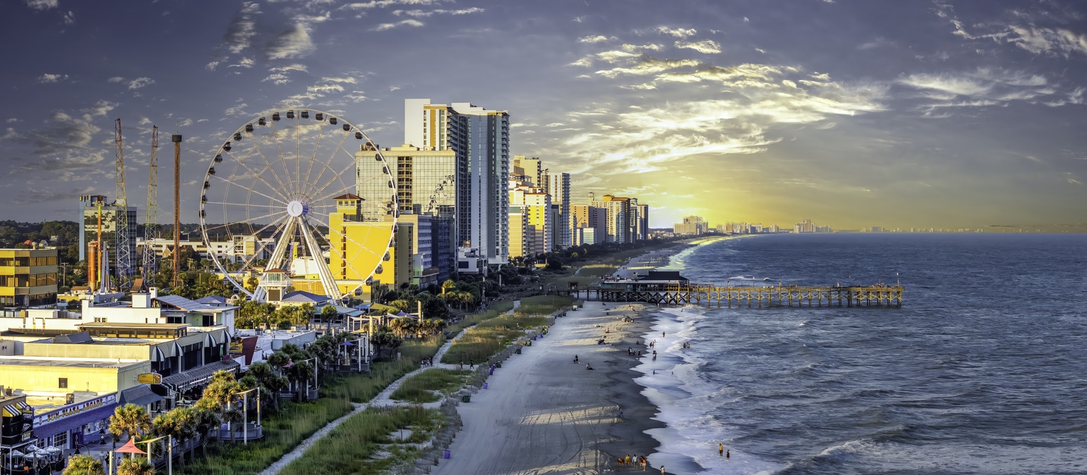 Sunrise over Myrtle Beach with its SkyWheel, hotel skyline, and pier, a beautiful sight for those living in Myrtle Beach