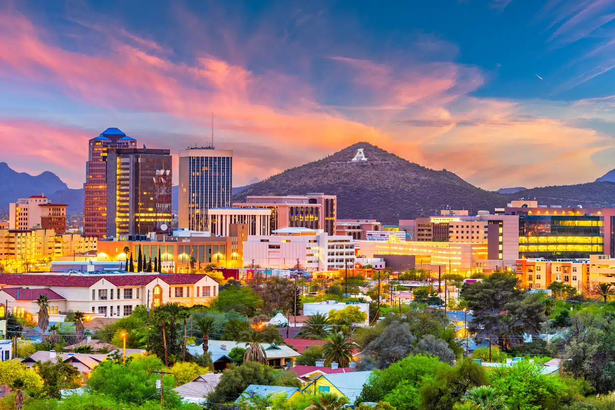 A vibrant sunset over the Tucson, Arizona, skyline, featuring buildings and the "A" on Sentinel Peak