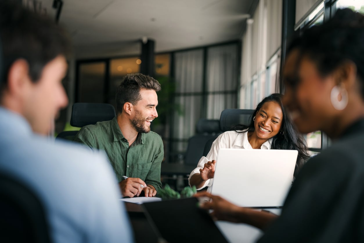A diverse group of students collaborating in a bright, modern office space after moving for a master’s degree