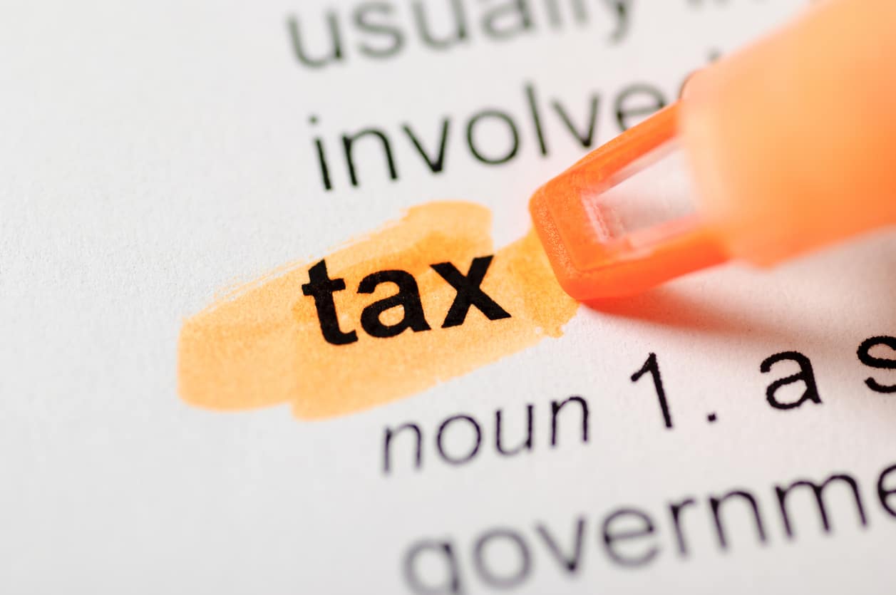 An orange highlighter marks the word “tax” in a dictionary entry