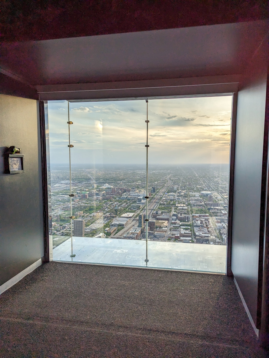 Aerial view of a city skyline and horizon from a high-floor glass enclosure