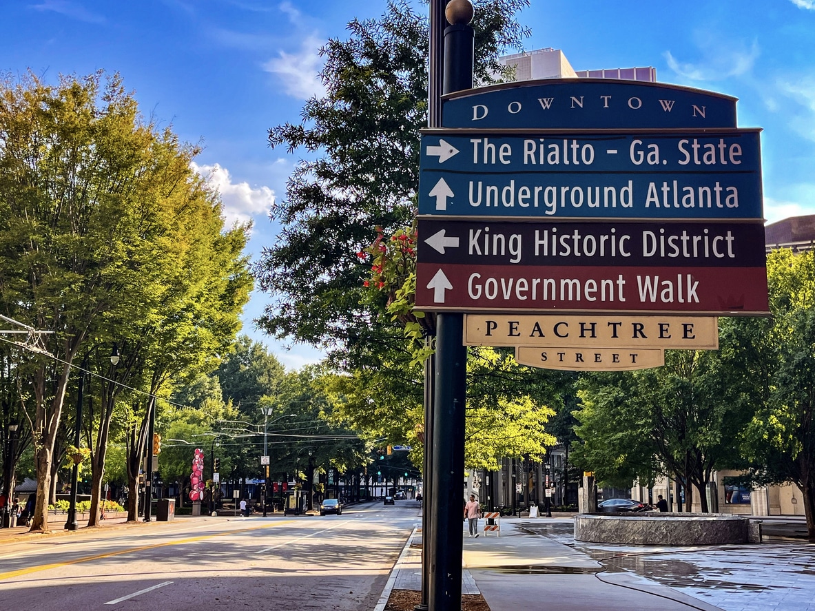 Street Sign On Peachtree Street In Downtown Atlanta A blue directional sign for Peachtree Street and local landmarks on a tree-lined Atlanta street