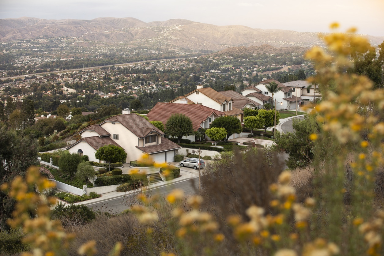 A sprawling suburban Orange County neighborhood, showcasing large, beautiful homes and a hillside backdrop