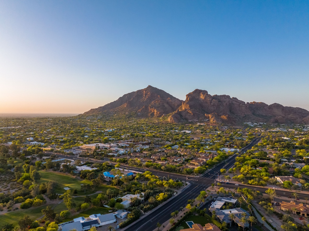 A sprawling suburban Scottsdale neighborhood stretching toward a large, sunlit mountain at sunset