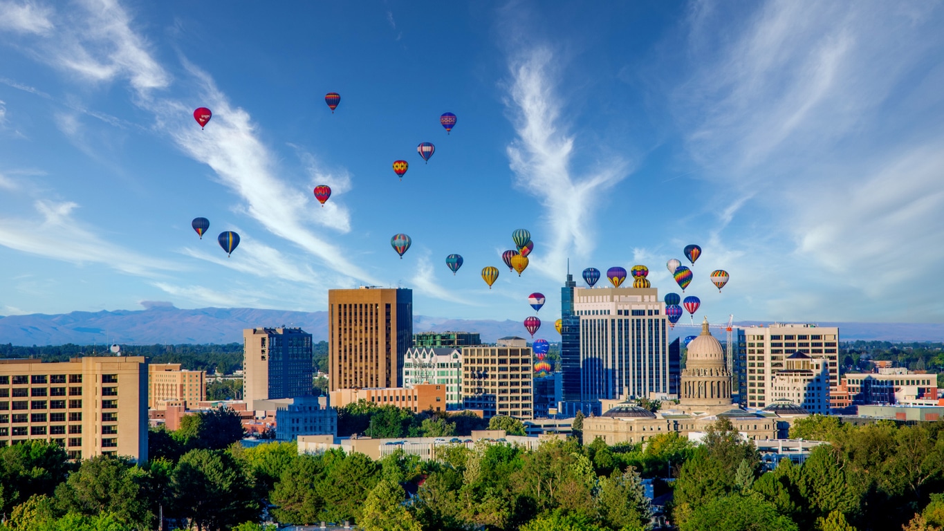 Numerous colorful hot air balloons float over a blue Idaho skyline, a not uncommon sight for those living in Idaho