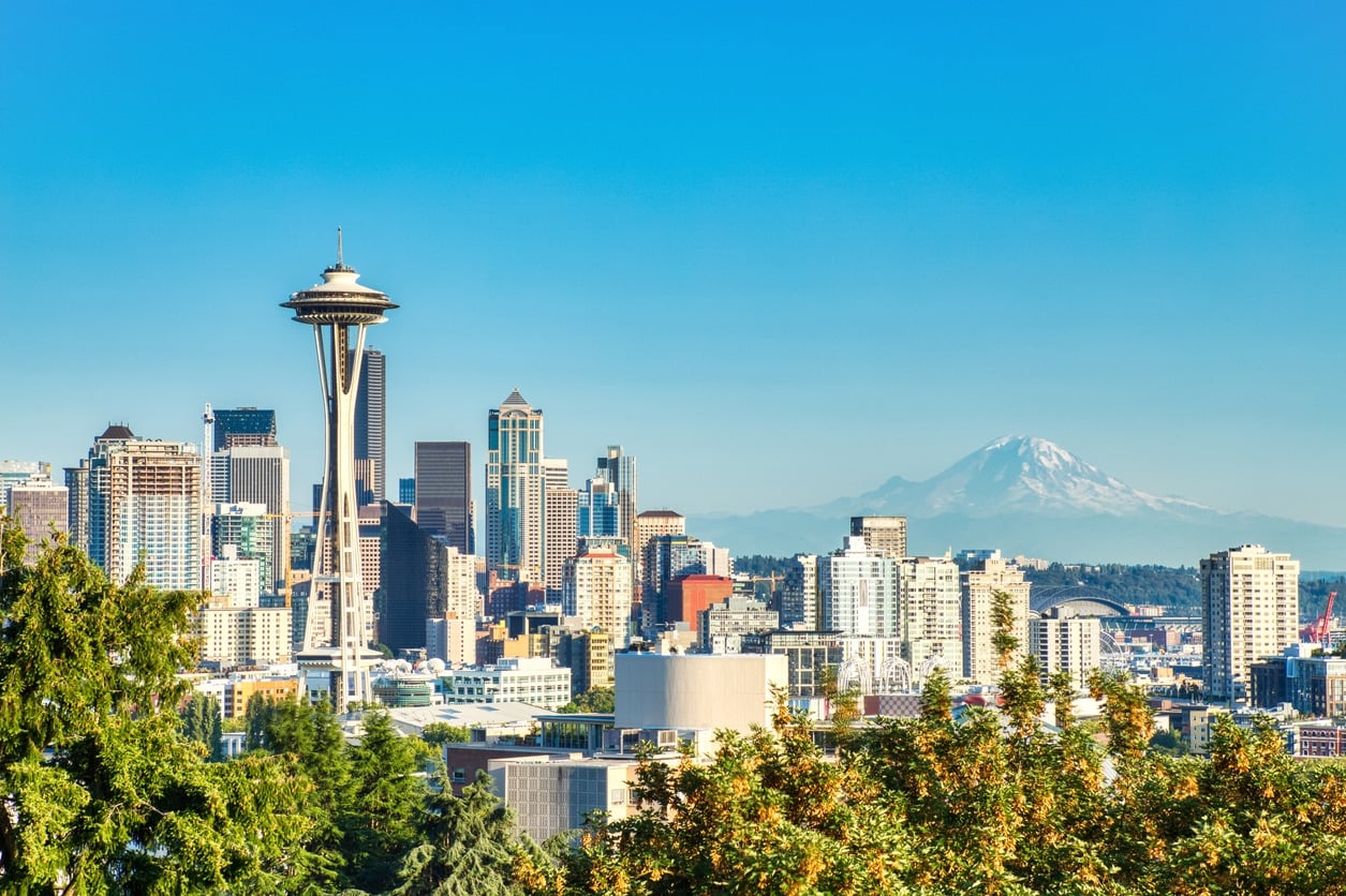 The Seattle skyline featuring the Space Needle, with Mount Rainier visible in the background under a blue sky