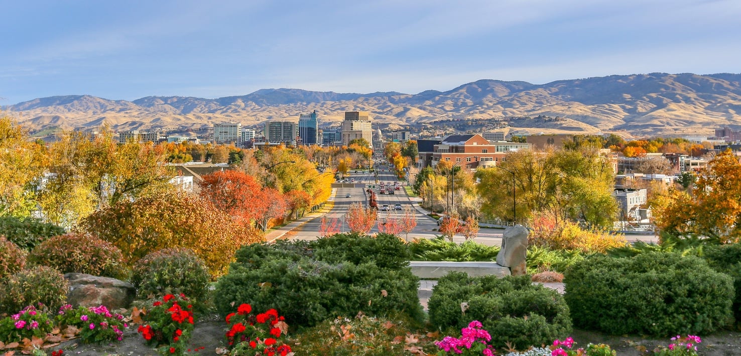 A scenic view showing what living in Boise, Idaho, is like, with autumn trees and a mountain range in the background