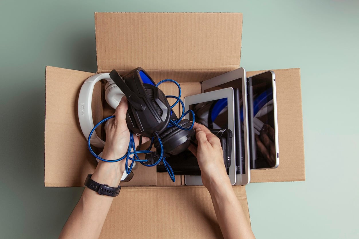 A person packing headphones and several tablets showing how to pack electronics for moving