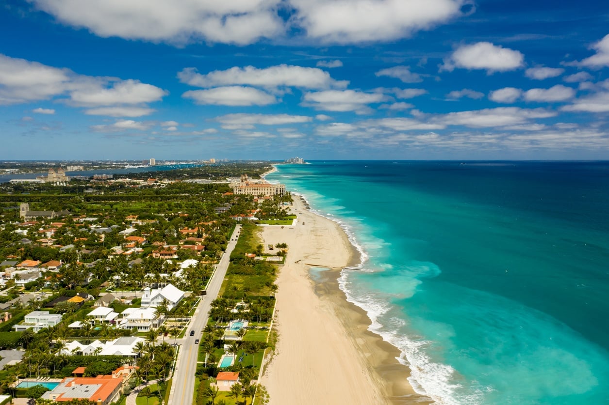 Aerial view of a West Palm Beach neighborhood along the coastline, showcasing sandy beaches and turquoise water
